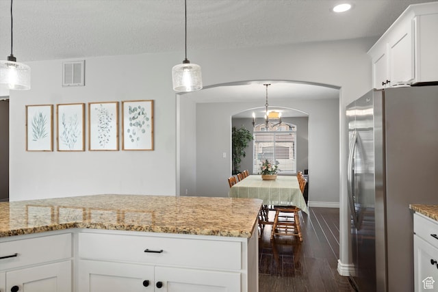 277 N 3600 W, Layton, UT 84041 - kitchen featuring freestanding refrigerator, arched walkways, dark wood finished floors, white cabinetry, and light stone counters