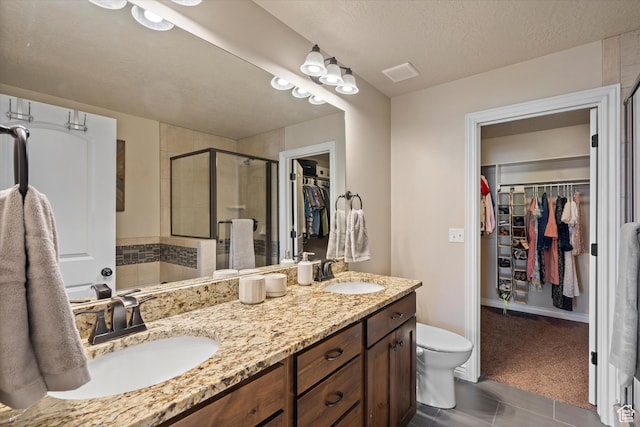 277 N 3600 W, Layton, UT 84041 - bathroom featuring a spacious closet, double vanity, a stall shower, toilet, and a textured ceiling