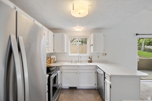 1694 E Plata Way, Sandy, UT 84093 - kitchen with appliances with stainless steel finishes, a sink, a peninsula, a textured ceiling, and white cabinetry