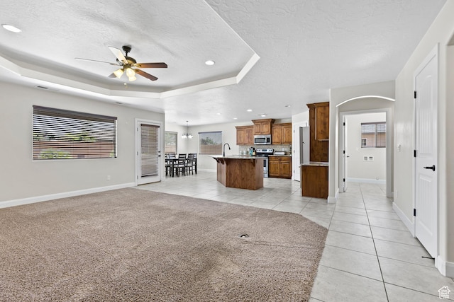 3345 W 2430 S, Hurricane, UT 84737 - unfurnished living room featuring a ceiling fan, light tile patterned floors, a textured ceiling, baseboards, and a tray ceiling