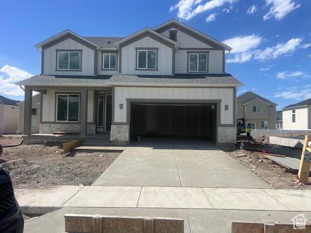 452 W Sapphire Dr Unit 7015, Tooele, UT 84074 - view of front of house featuring an attached garage, concrete driveway, a shingled roof, and board and batten siding
