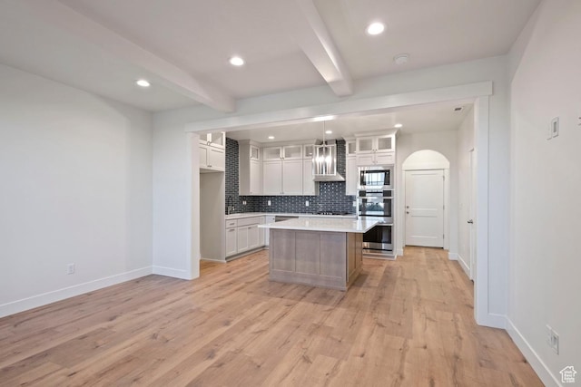 11433 S Watercourse Rd Unit 184, South Jordan, UT 84009 - kitchen featuring built in microwave, wall chimney range hood, stainless steel double oven, beam ceiling, and decorative backsplash