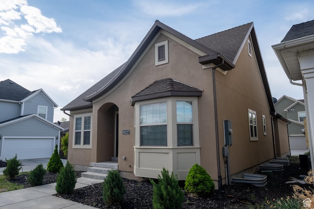 10227 S Oquirrh Lake Rd, South Jordan, UT 84095 - view of front facade with stucco siding, a garage, an outbuilding, and a shingled roof