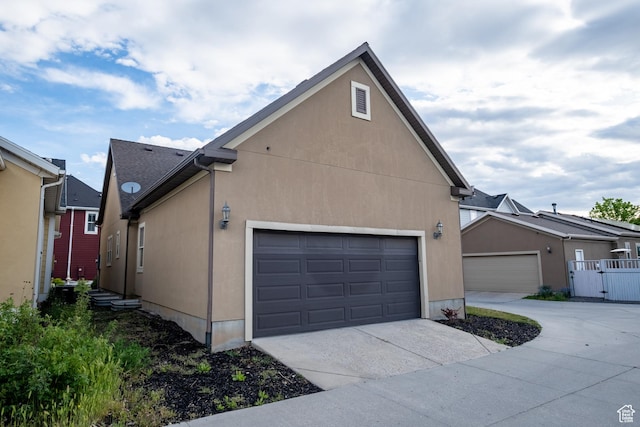 10227 S Oquirrh Lake Rd, South Jordan, UT 84095 - view of side of home featuring driveway, stucco siding, and a garage