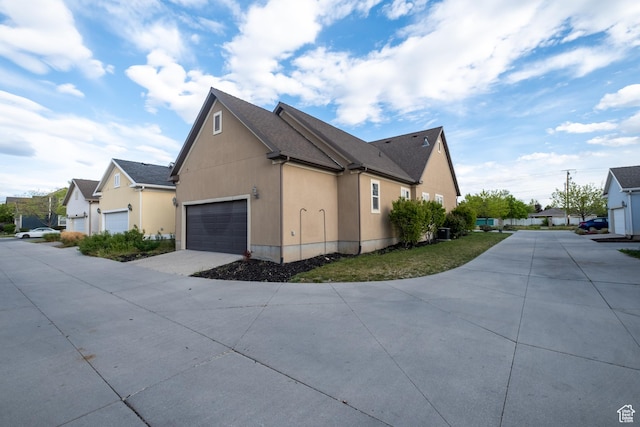 10227 S Oquirrh Lake Rd, South Jordan, UT 84095 - view of home's exterior with driveway, stucco siding, a garage, and a residential view