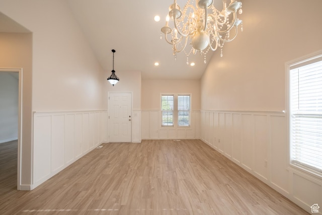 10227 S Oquirrh Lake Rd, South Jordan, UT 84095 - empty room featuring a chandelier, light wood-style floors, wainscoting, a decorative wall, and high vaulted ceiling