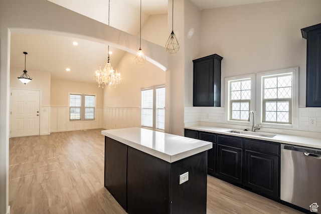 10227 S Oquirrh Lake Rd, South Jordan, UT 84095 - kitchen with stainless steel dishwasher, a sink, dark cabinets, a wainscoted wall, and high vaulted ceiling
