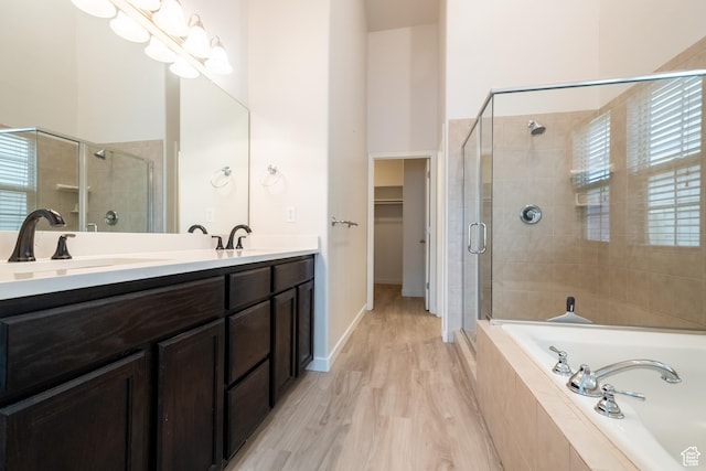 10227 S Oquirrh Lake Rd, South Jordan, UT 84095 - full bathroom featuring a stall shower, a garden tub, double vanity, a walk in closet, and wood finished floors