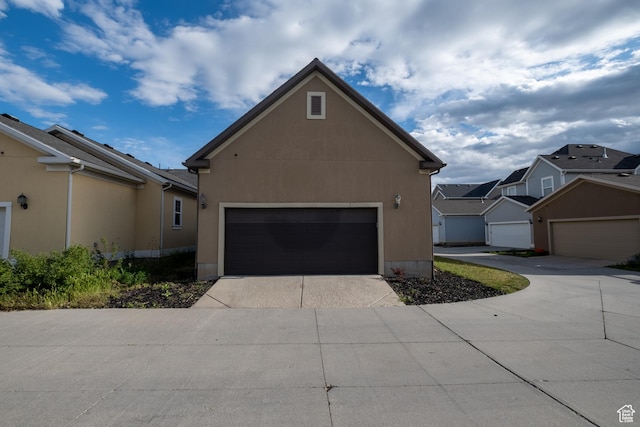 10227 S Oquirrh Lake Rd, South Jordan, UT 84095 - view of home's exterior featuring concrete driveway, stucco siding, a garage, and a residential view