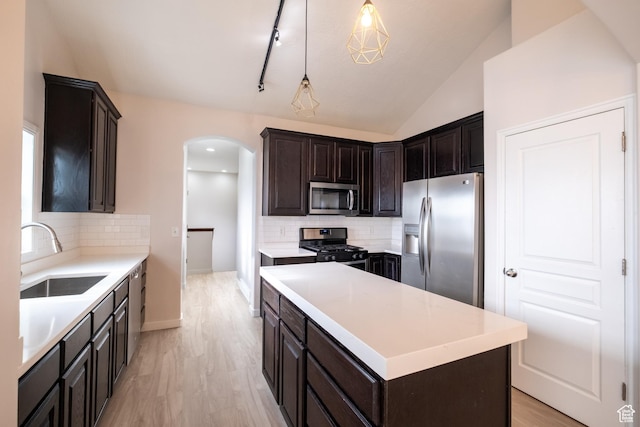 10227 S Oquirrh Lake Rd, South Jordan, UT 84095 - kitchen featuring stainless steel appliances, a sink, arched walkways, tasteful backsplash, and lofted ceiling