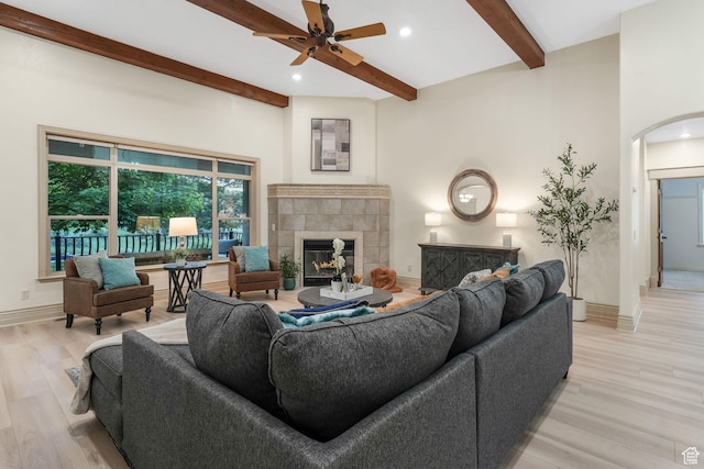 584 S Silver Ln, Alpine, UT 84004 - living area featuring a tile fireplace, arched walkways, beam ceiling, light wood finished floors, and ceiling fan