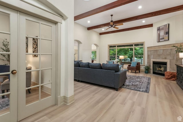 584 S Silver Ln, Alpine, UT 84004 - living room with arched walkways, beamed ceiling, light wood-style flooring, a ceiling fan, and a tile fireplace