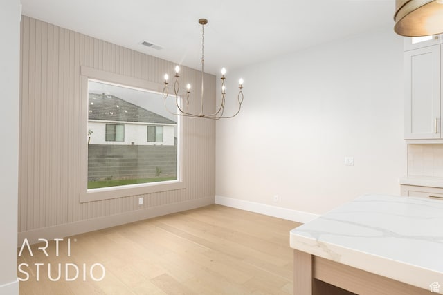2921 E Yavin Way, St George, UT 84790 - unfurnished dining area featuring light wood-style floors, baseboards, and a chandelier