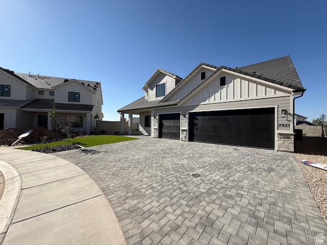 2921 E Yavin Way, St George, UT 84790 - view of front facade featuring board and batten siding, decorative driveway, stone siding, and an attached garage