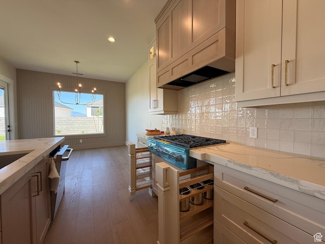 2921 E Yavin Way, St George, UT 84790 - kitchen with dark wood finished floors, a chandelier, light stone countertops, stainless steel gas cooktop, and dishwashing machine