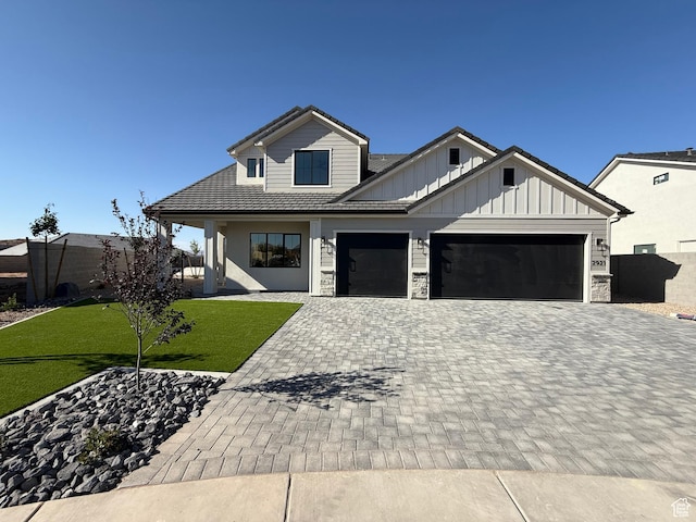 2921 E Yavin Way, St George, UT 84790 - modern farmhouse style home with decorative driveway, an attached garage, board and batten siding, a front yard, and stone siding