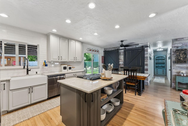 623 N 120 W, Lehi, UT 84043 - kitchen featuring dishwasher, a sink, a barn door, open shelves, and light wood-style flooring