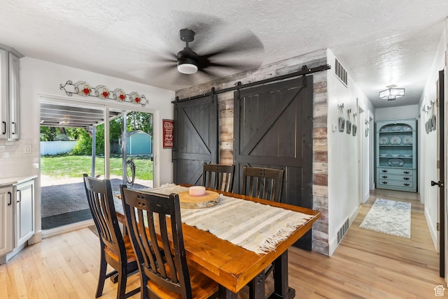 623 N 120 W, Lehi, UT 84043 - dining space with a barn door, light wood-style floors, ceiling fan, and a textured ceiling