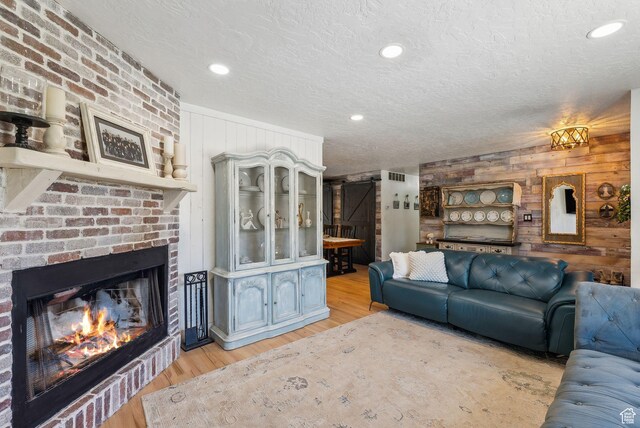 623 N 120 W, Lehi, UT 84043 - living room with wood walls, a textured ceiling, light wood-type flooring, a fireplace, and recessed lighting