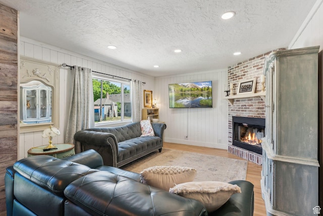 623 N 120 W, Lehi, UT 84043 - living room featuring a textured ceiling, light wood-style flooring, a fireplace, baseboards, and recessed lighting