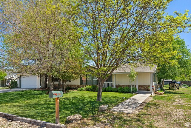 245 S 400 W, Heber City, UT 84032 - view of property hidden behind natural elements with a front lawn, an attached garage, asphalt driveway, and stone siding