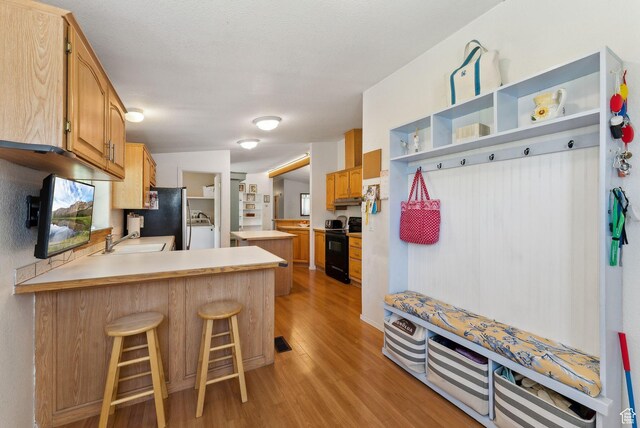 245 S 400 W, Heber City, UT 84032 - kitchen with electric range, washer / clothes dryer, a sink, a peninsula, and freestanding refrigerator