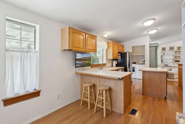 245 S 400 W, Heber City, UT 84032 - kitchen featuring stainless steel fridge with ice dispenser, a sink, light countertops, washing machine and dryer, and light wood finished floors