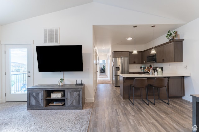 1994 N 3330 W Unit A304, Lehi, UT 84043 - kitchen with appliances with stainless steel finishes, vaulted ceiling, dark brown cabinets, a kitchen breakfast bar, and light countertops