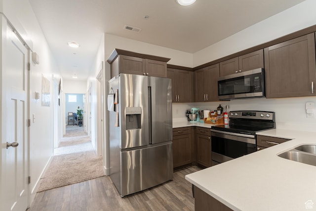 1994 N 3330 W Unit A304, Lehi, UT 84043 - kitchen featuring stainless steel appliances, light wood-style flooring, light countertops, and dark brown cabinets