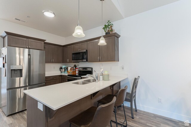 1994 N 3330 W Unit A304, Lehi, UT 84043 - kitchen with stainless steel appliances, a sink, light wood-type flooring, a peninsula, and a kitchen bar