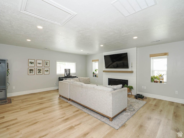 8701 S 1365 W, West Jordan, UT 84088 - living area featuring recessed lighting, a textured ceiling, light wood finished floors, baseboards, and a fireplace