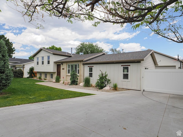 8701 S 1365 W, West Jordan, UT 84088 - split level home featuring concrete driveway, board and batten siding, a front yard, and a shingled roof