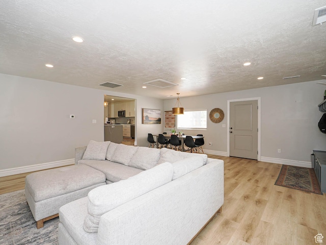 8701 S 1365 W, West Jordan, UT 84088 - living room with light wood finished floors, baseboards, recessed lighting, and a textured ceiling