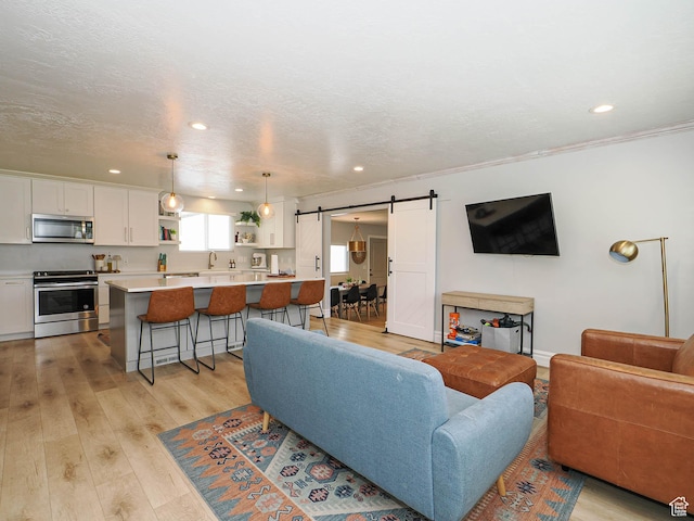 8701 S 1365 W, West Jordan, UT 84088 - living area featuring a barn door, recessed lighting, light wood-style floors, and a textured ceiling