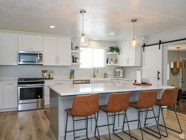 8701 S 1365 W, West Jordan, UT 84088 - kitchen featuring appliances with stainless steel finishes, open shelves, a sink, a textured ceiling, and white cabinetry
