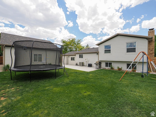 8701 S 1365 W, West Jordan, UT 84088 - back of property featuring a trampoline, a patio, a yard, and cooling unit