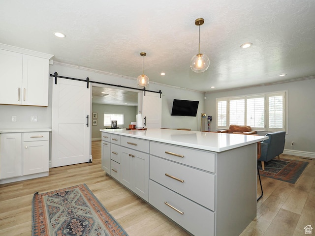 8701 S 1365 W, West Jordan, UT 84088 - kitchen featuring a barn door, a kitchen island, light countertops, white cabinetry, and a textured ceiling