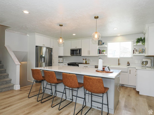 8701 S 1365 W, West Jordan, UT 84088 - kitchen featuring appliances with stainless steel finishes, open shelves, a sink, white cabinetry, and a textured ceiling