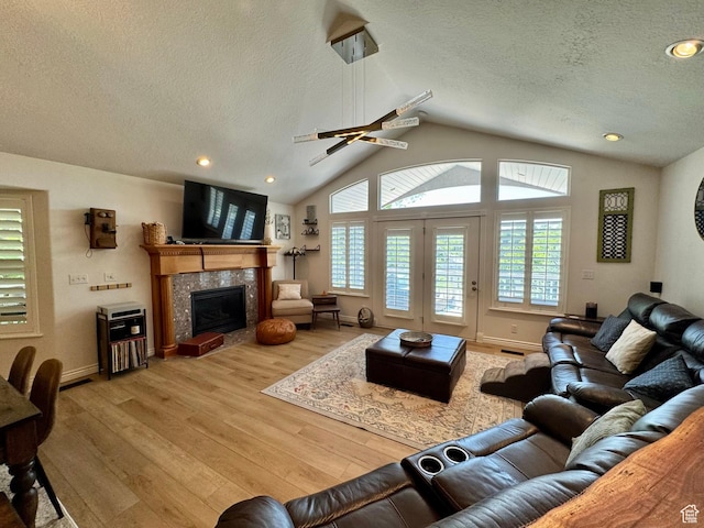 1710 N 2625 E, Layton, UT 84040 - living room featuring a textured ceiling, a fireplace, light wood-type flooring, lofted ceiling, and baseboards