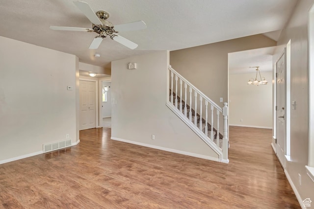 4733 S 3900 W, Roy, UT 84067 - empty room featuring wood finished floors, stairway, ceiling fan, and a chandelier