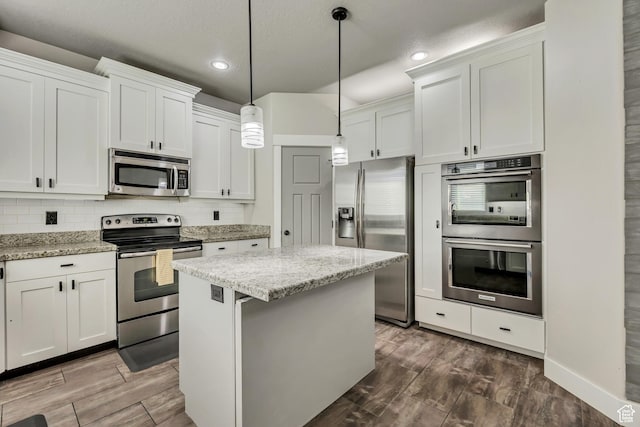 12884 S Tortoise Ln, Riverton, UT 84096 - kitchen with stainless steel appliances, a center island, recessed lighting, tasteful backsplash, and white cabinetry