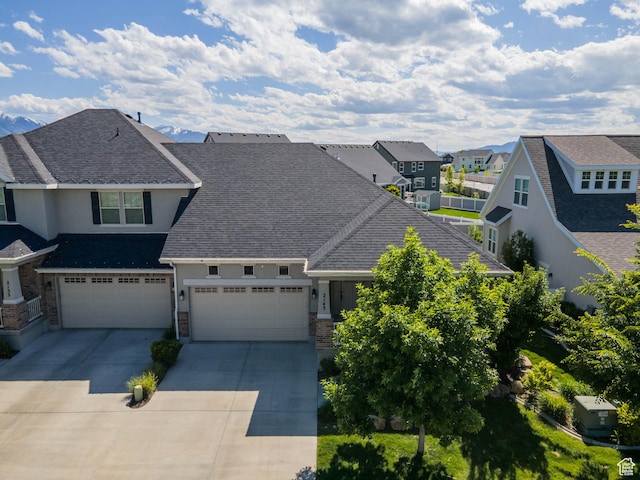 2143 W River Birch Rd, Mapleton, UT 84664 - view of front of house with a residential view, stucco siding, concrete driveway, roof with shingles, and stone siding