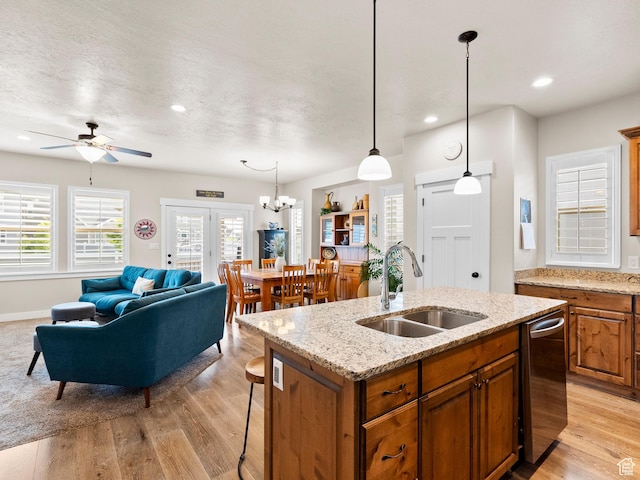 2143 W River Birch Rd, Mapleton, UT 84664 - kitchen with a sink, brown cabinets, stainless steel dishwasher, a center island with sink, and light wood-style floors