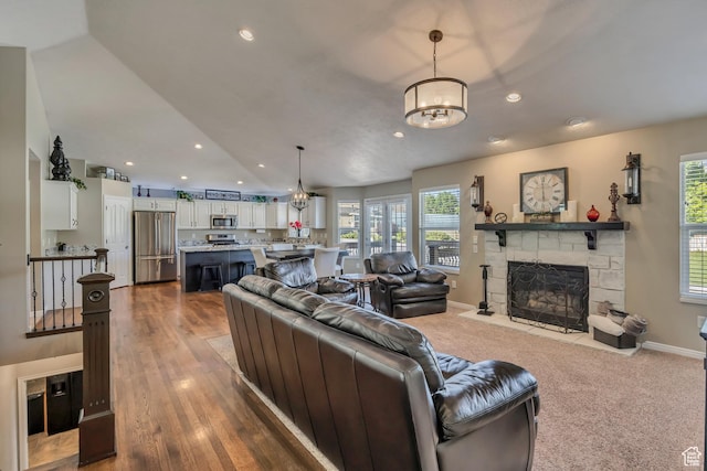 11743 S Silver Spur Ln, Draper, UT 84020 - living area featuring a chandelier, a stone fireplace, healthy amount of natural light, recessed lighting, and baseboards