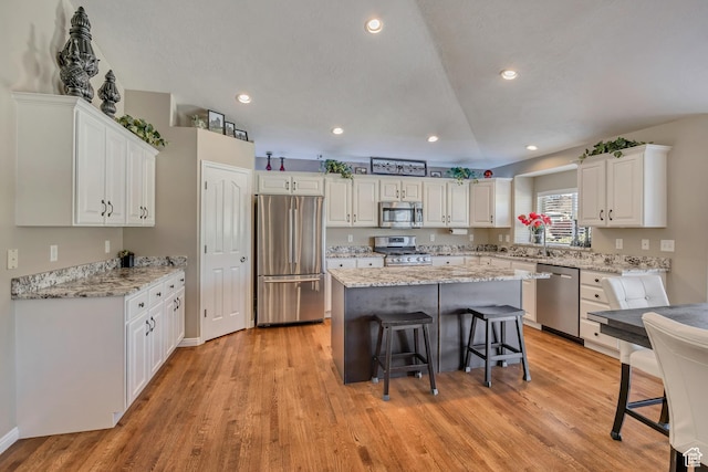 11743 S Silver Spur Ln, Draper, UT 84020 - kitchen with stainless steel appliances, a kitchen bar, white cabinetry, a center island, and recessed lighting