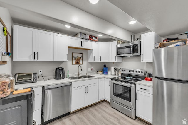 18616 Jefferson Ave, Eagle Mountain, UT 84013 - kitchen with stainless steel appliances, a sink, white cabinetry, light wood finished floors, and recessed lighting