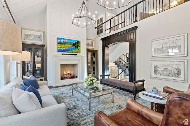 4731 S Marabow Cir, Holladay, UT 84117 - living room featuring high vaulted ceiling, arched walkways, a lit fireplace, a chandelier, and baseboards
