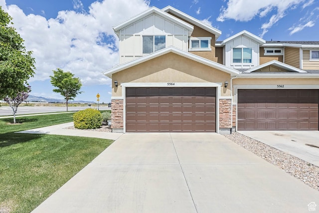 5564 W Baldrine Ct, Herriman, UT 84096 - view of front of property with stone siding, driveway, a front lawn, and board and batten siding