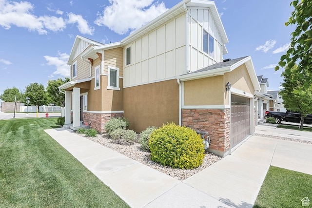 5564 W Baldrine Ct, Herriman, UT 84096 - view of side of property with stone siding, a garage, board and batten siding, and driveway