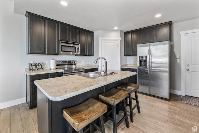 5564 W Baldrine Ct, Herriman, UT 84096 - kitchen featuring stainless steel appliances, a sink, baseboards, light wood-style floors, and light countertops